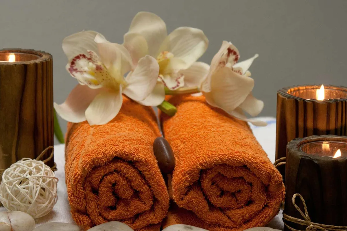 Premium oil massage setup with towels and spa candles at Maneerat Wellness